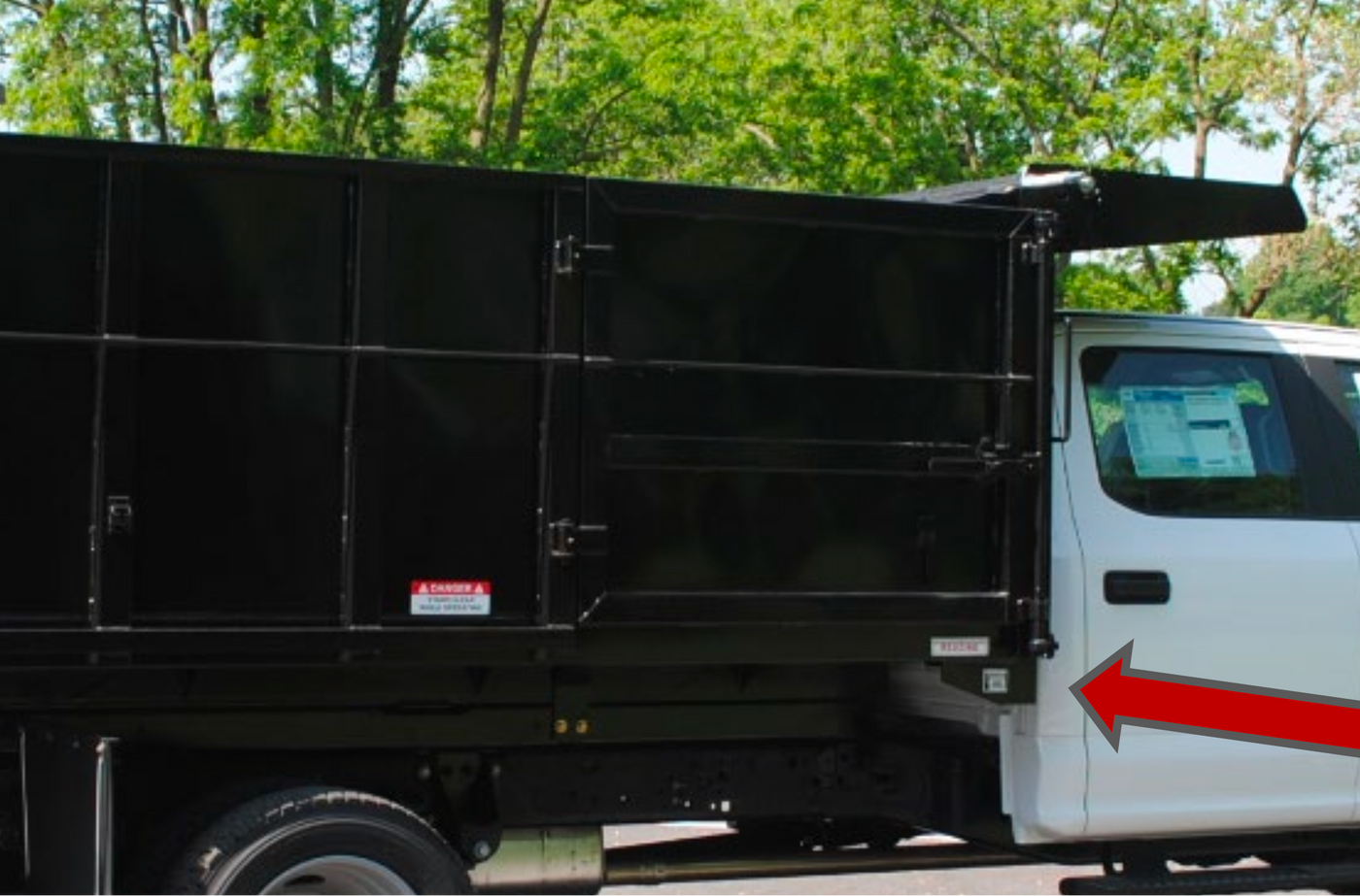 White truck with a black cargo bed on a road with trees in the background